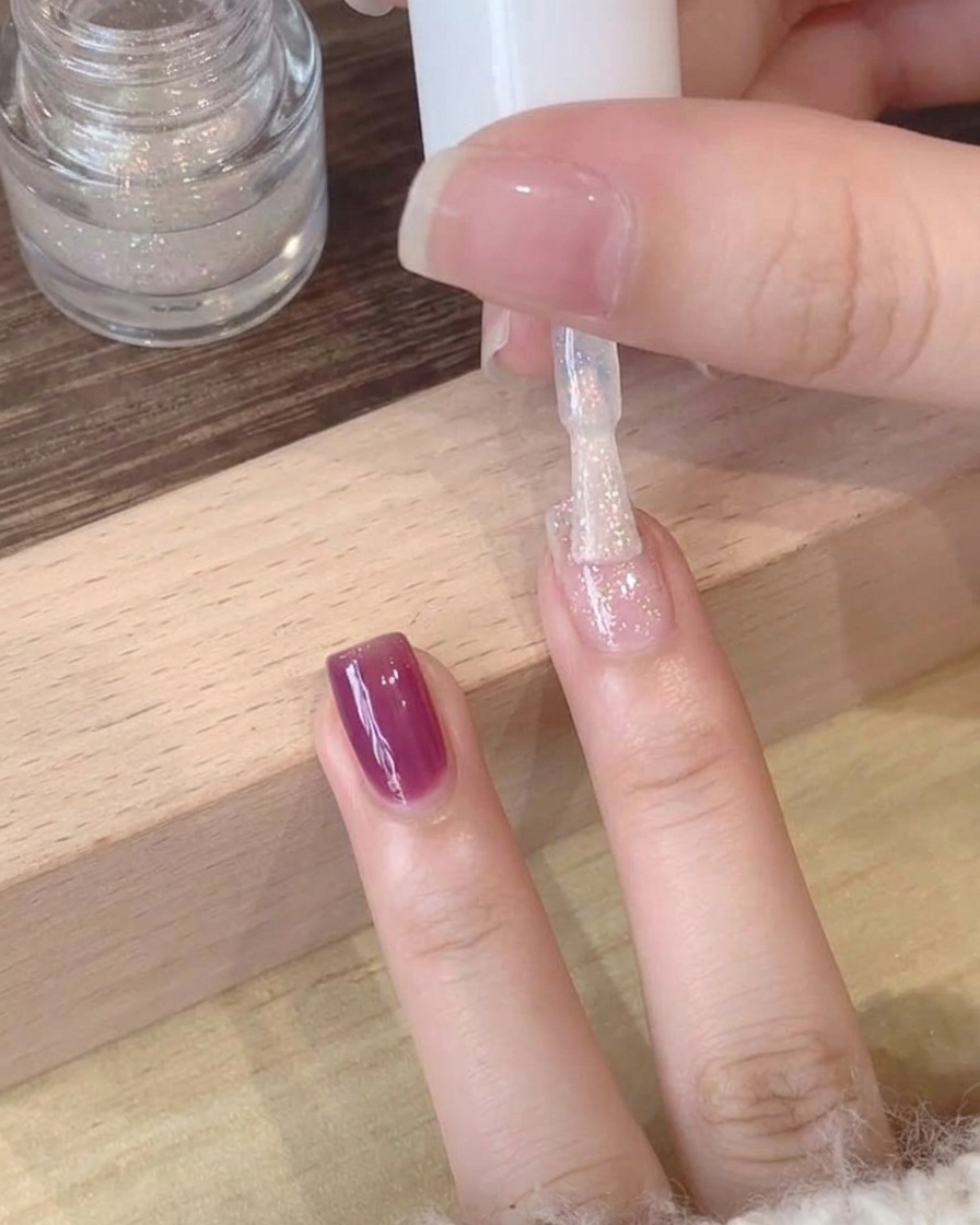 Zbliżenie na mieniący się, polaryzacyjny top coat nakładany na fioletową bazę.