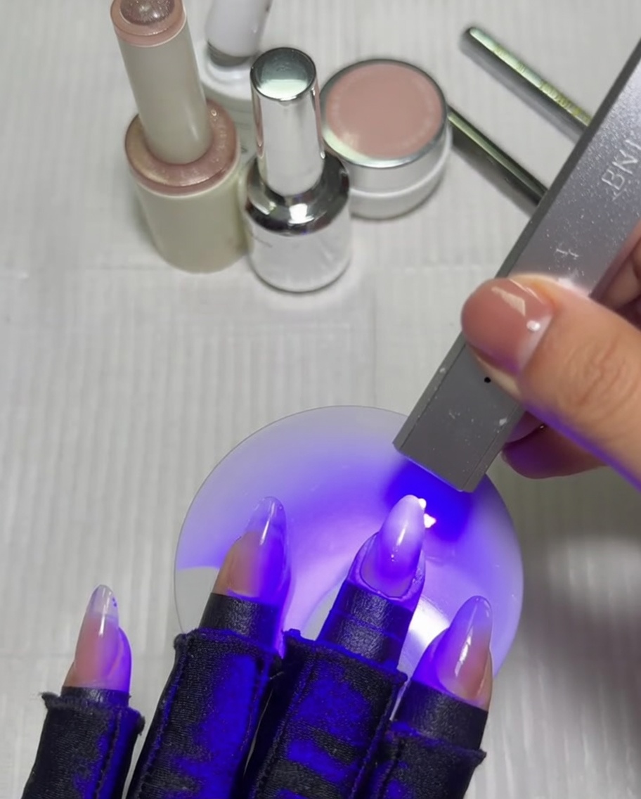 Dłoń z manicure gradientowym umieszczona w lampie UV/LED.