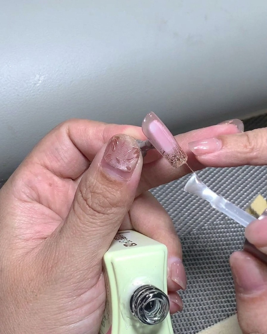 Pędzelek nakładający warstwę nabłyszczającą na gotowy manicure.