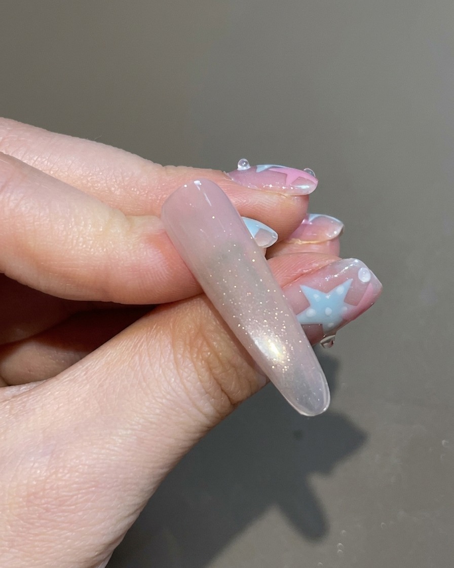 Pędzelek nakładający bezbarwny top coat na gotowy, magnetyczny paznokieć cat-eye.