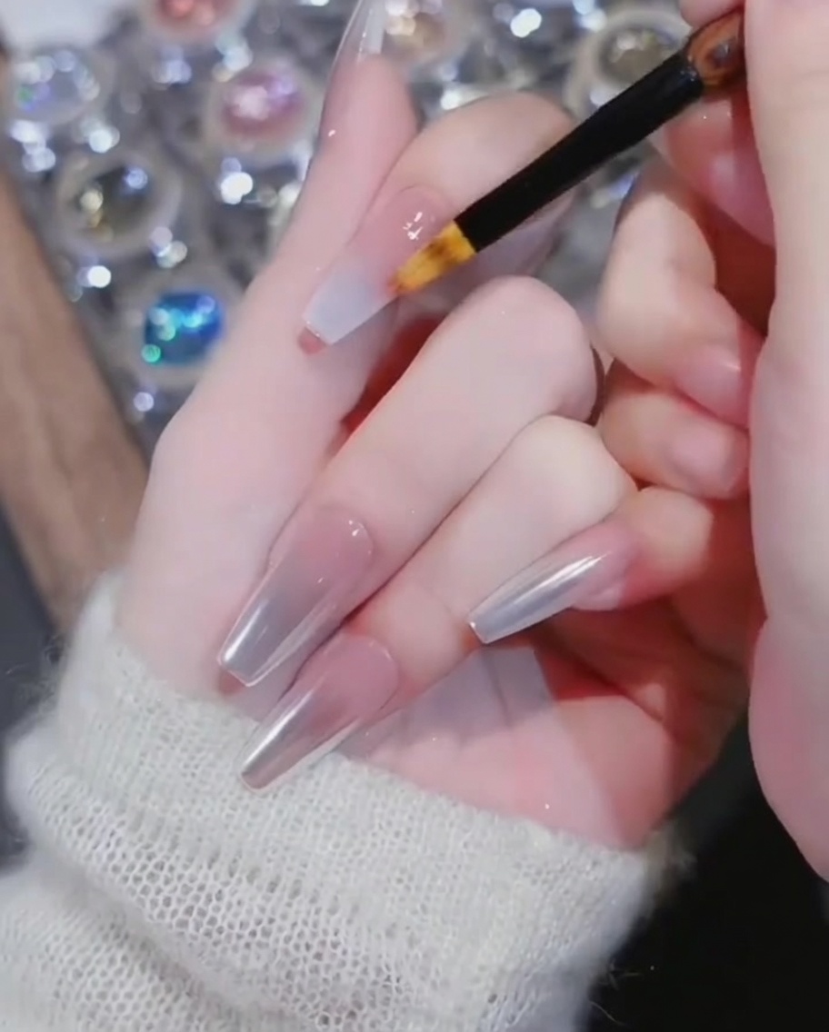 Pędzelek do cieniowania przeciągający biały żel w stronę nasady paznokcia.