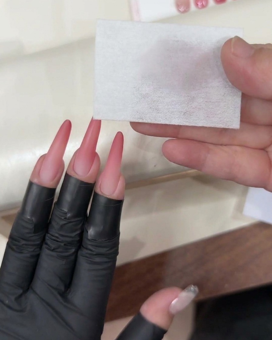 Pędzelek żelowy aplikujący przezroczysty, nabłyszczający top coat na gotowy różowy paznokieć ombré.