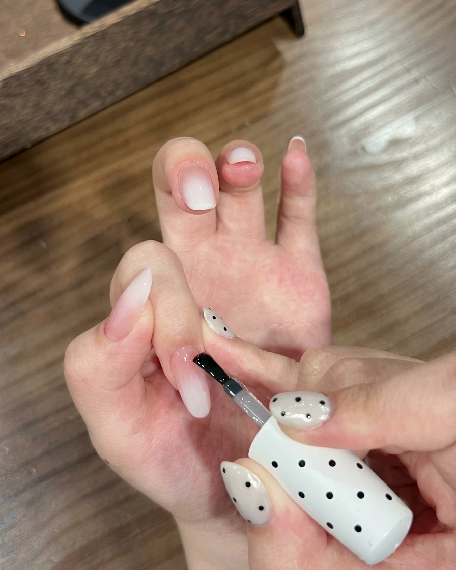 Zbliżenie dłoni z paznokciami ombre umieszczonymi wewnątrz lampy do paznokci UV.