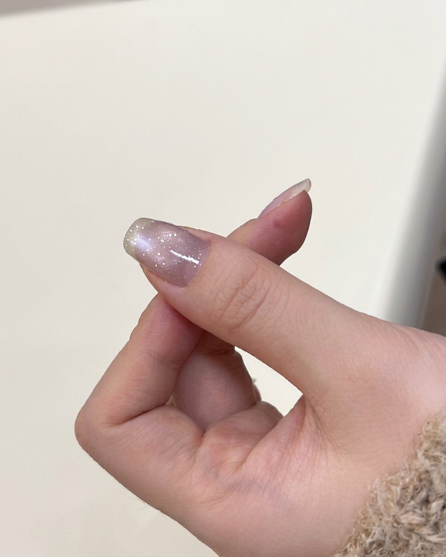 Dłoń wewnątrz lampy UV podczas utwardzania lakieru cat-eye.