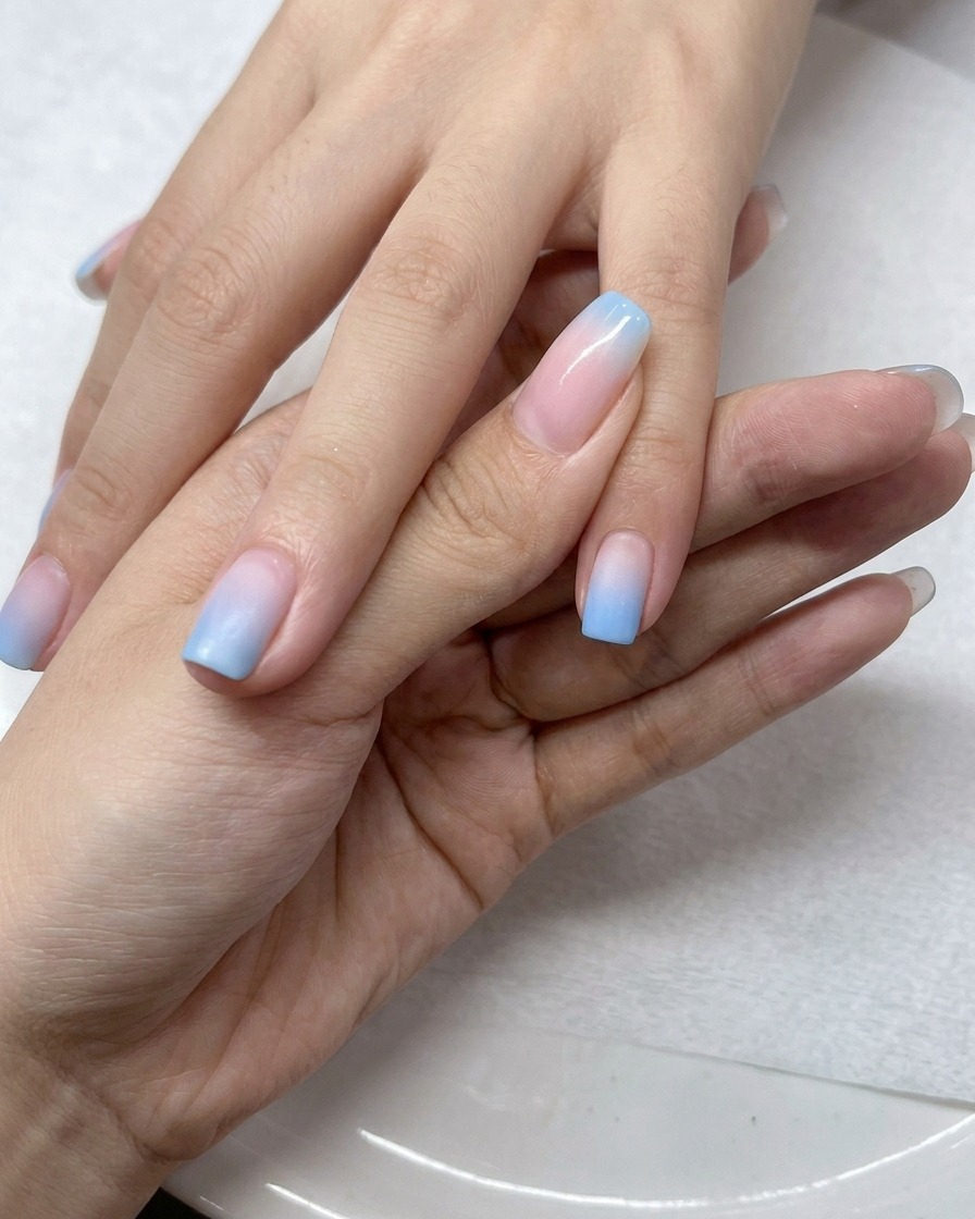 Pędzelek aplikujący przezroczysty top coat na paznokcie z efektem ombre.