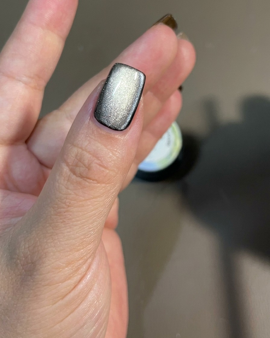 Magnes przesuwany nad powierzchnią paznokcia w celu ukierunkowania drobinek magnetycznych.