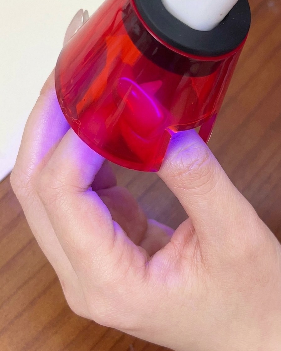 Palec utwardzany pod czerwoną lampą LED w celu utrwalenia wzoru magnetycznego.