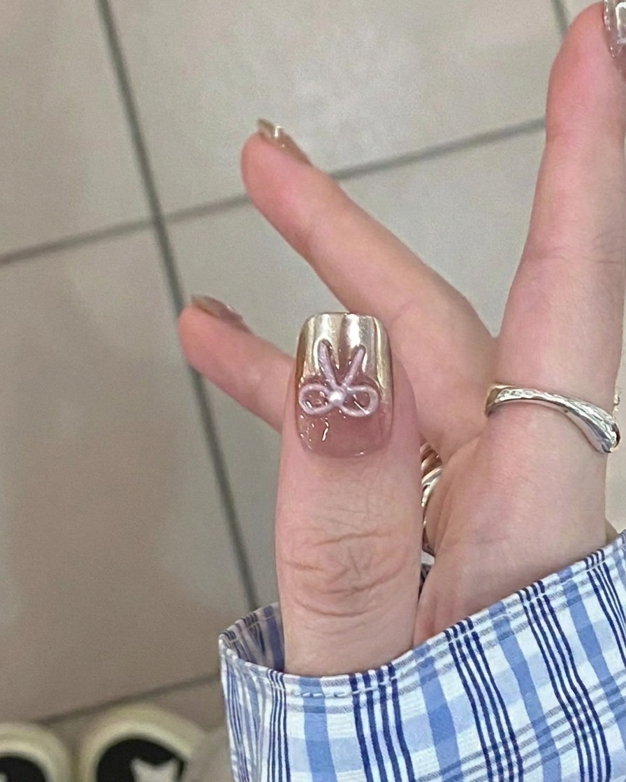 Zbliżenie na pędzelek nakładający transparentną bazę nude na czysty paznokieć.