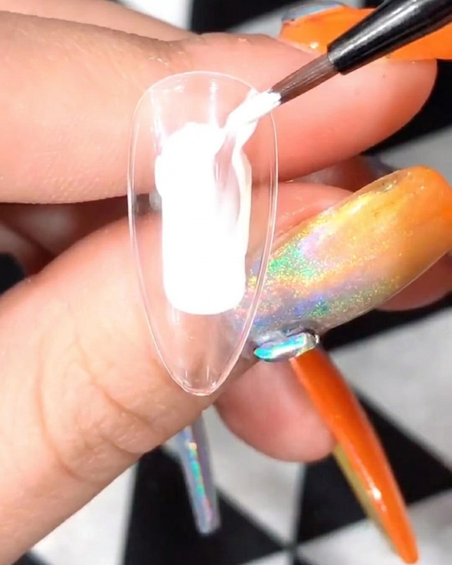 Przezroczysty tips z namalowanymi białymi płatkami utwardzany w lampie UV/LED.