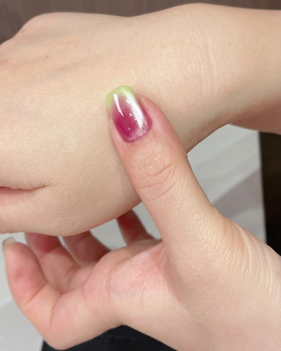 Dłoń umieszczona pod lampą UV w celu utwardzenia świeżo nałożonego żelu cat eye.