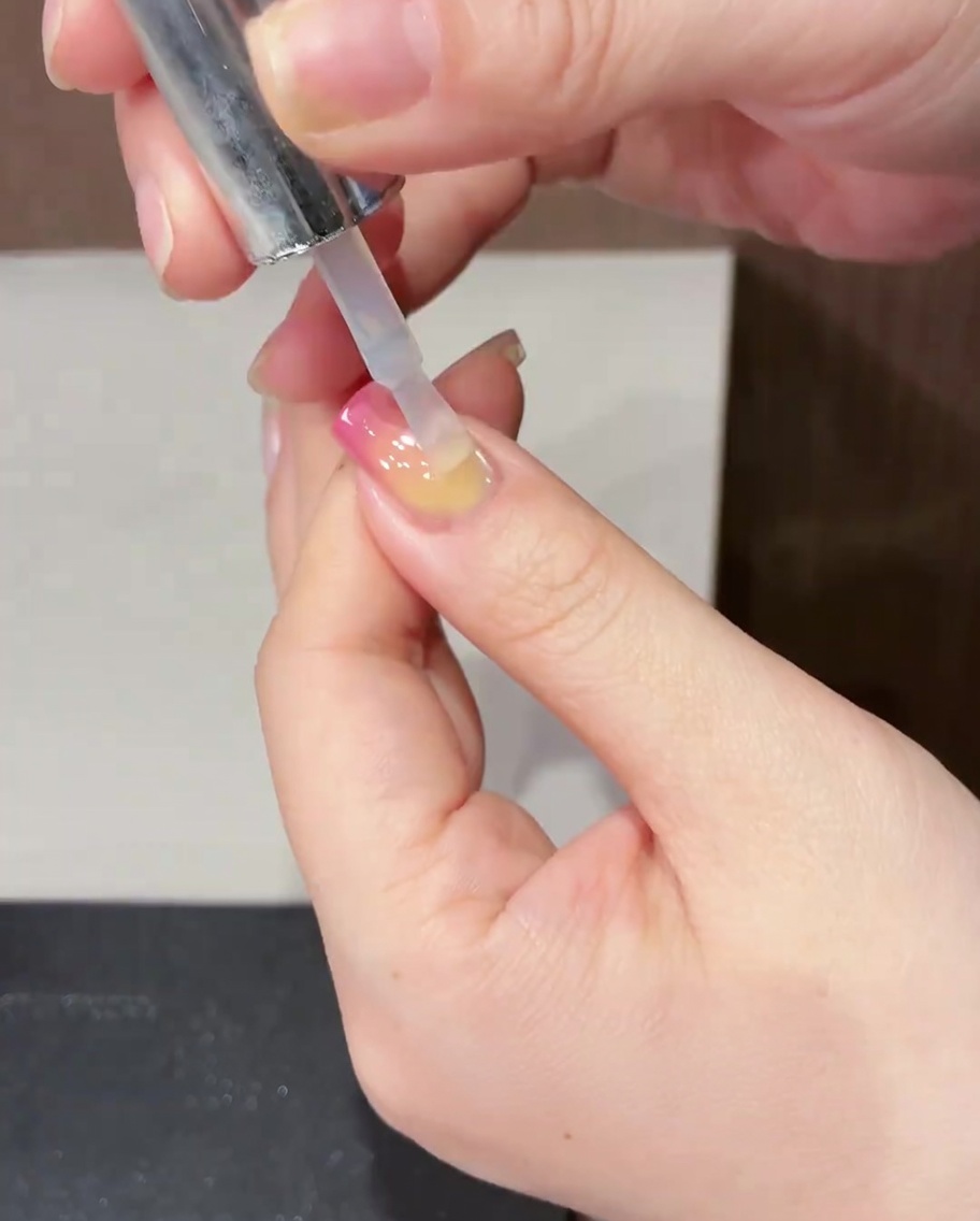 Pędzelek nakładający przezroczysty, błyszczący top coat na gotowy wzór.