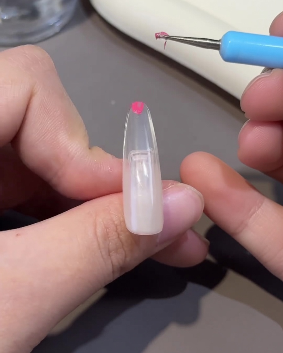 Tips utwardzany w lampie UV/LED z widoczną gładką powierzchnią żelu.