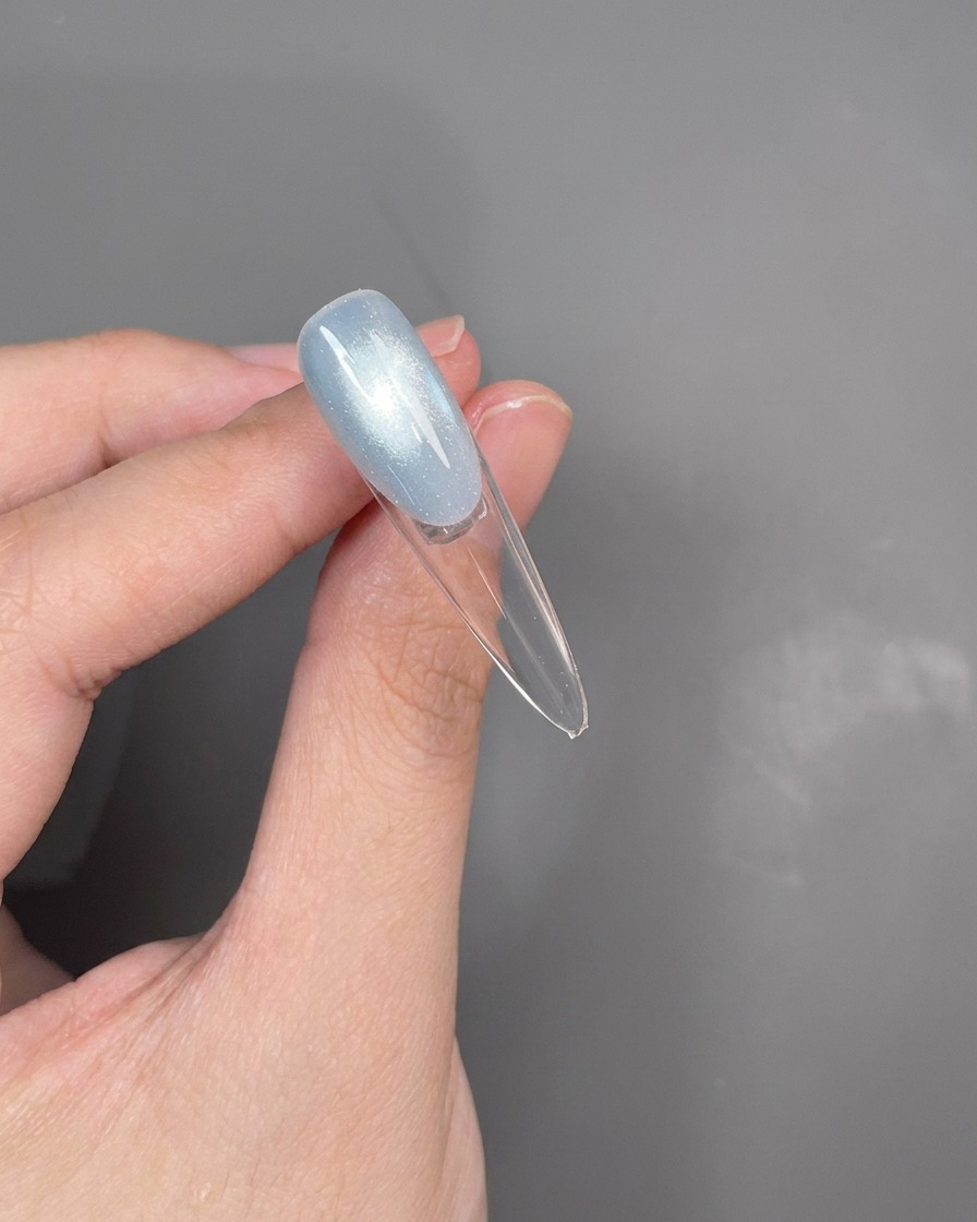 Zbliżenie na sondę tworzącą cienką srebrną linię wzdłuż linii uśmiechu french manicure.
