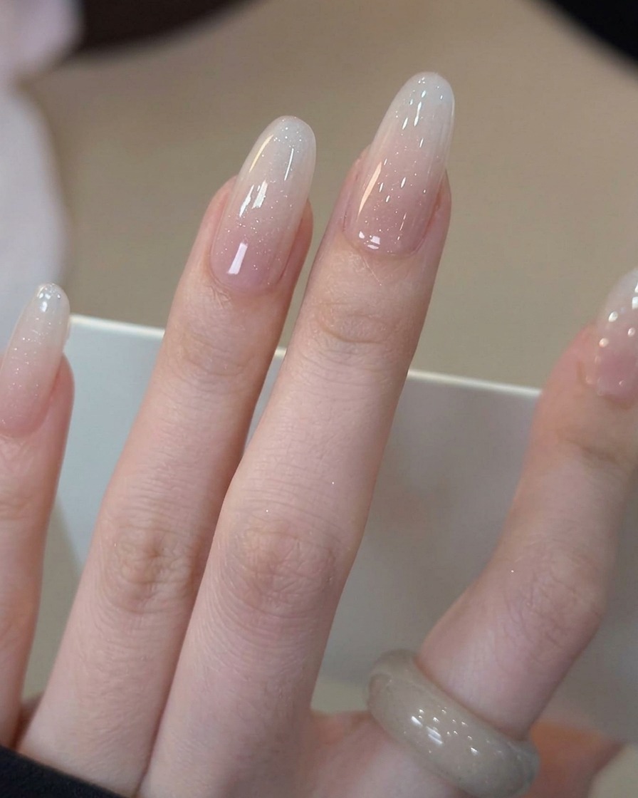 Pędzelek nakładający przezroczysty, błyszczący top na wykonany mleczny manicure.