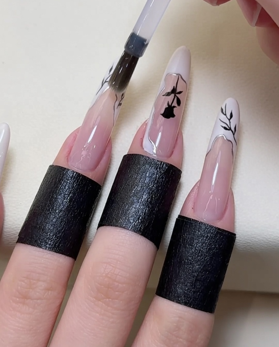 Pędzelek nakładający warstwę nabłyszczającego top coat na gotowy wzór.