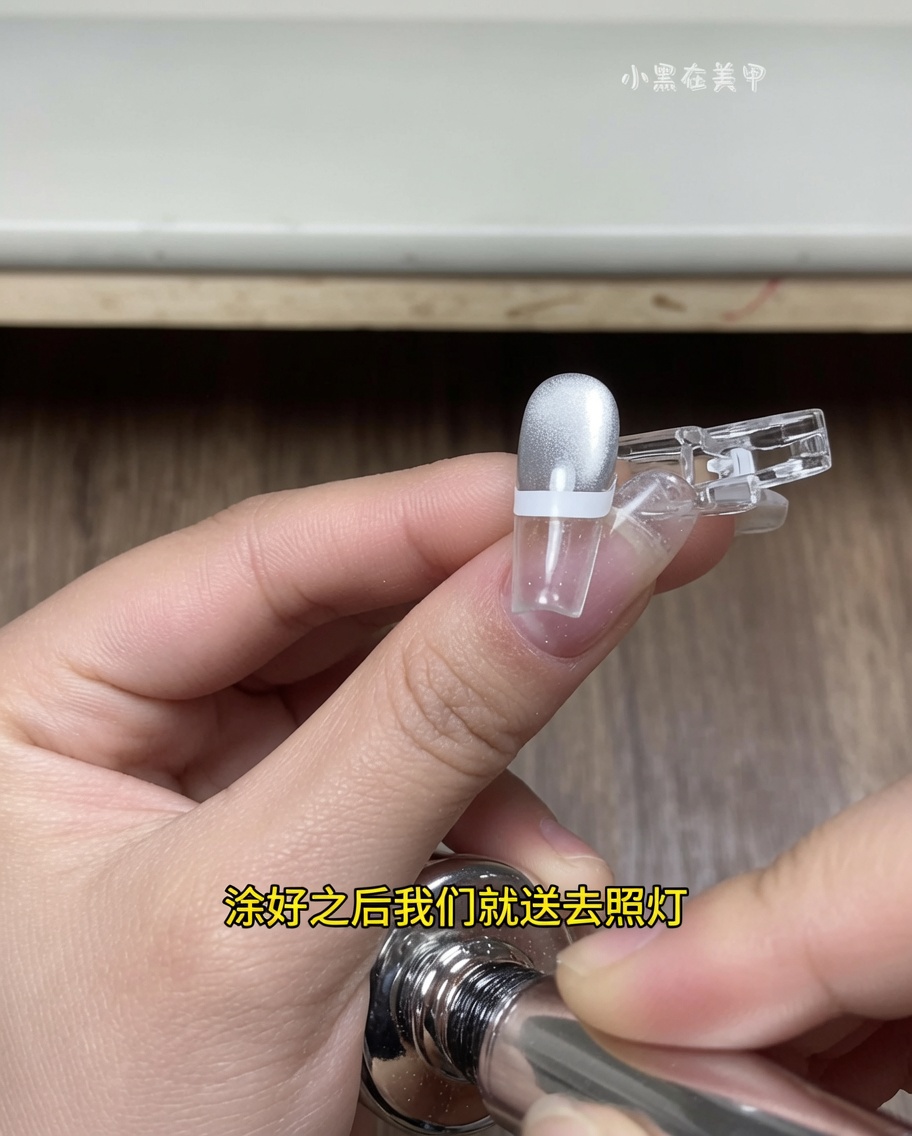 Palec z naklejonym paskiem do frencha umieszczony wewnątrz lampy UV/LED, z końcówką paznokcia pod źródłem światła.