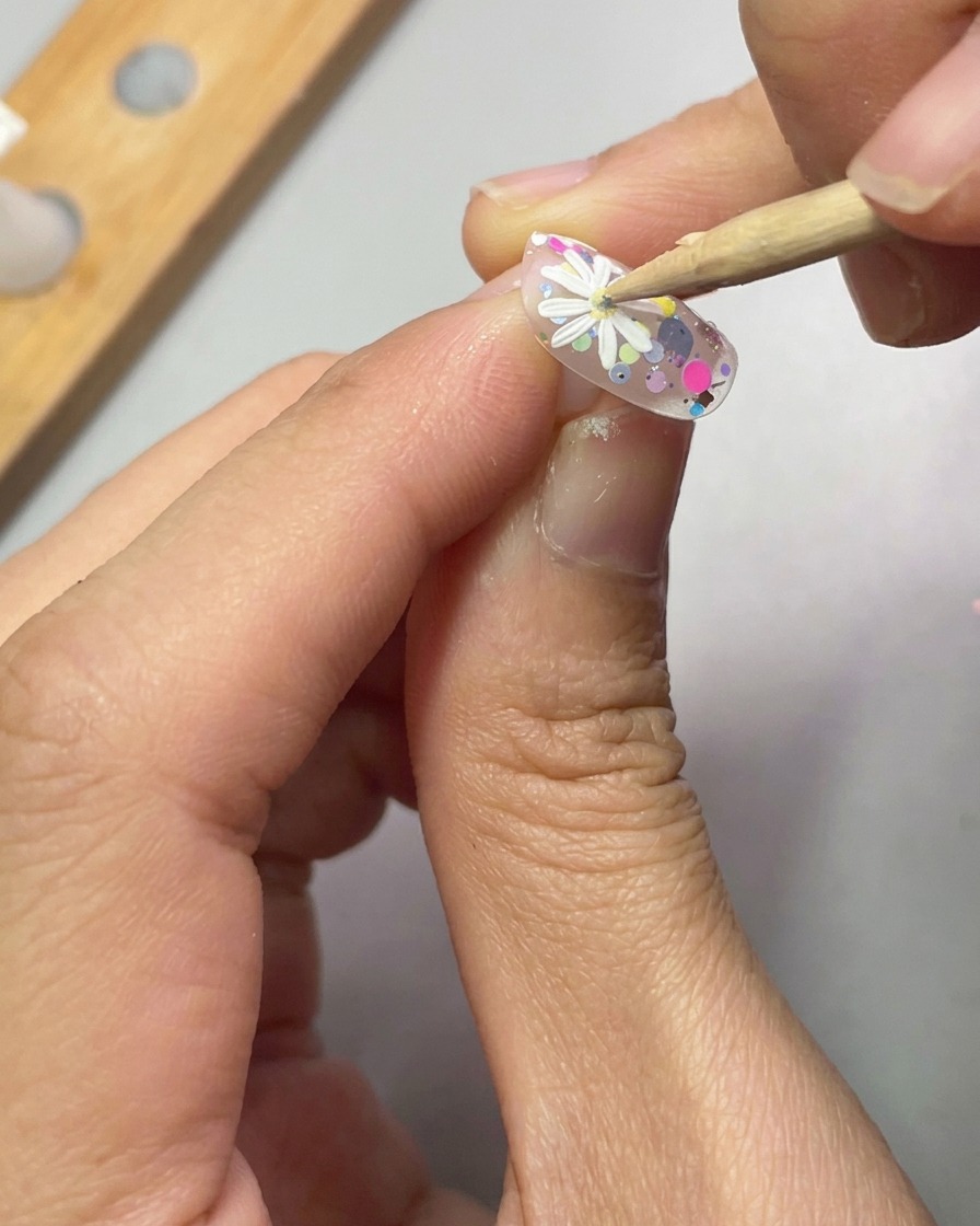 Sonda umieszczająca kroplę żółtego żelu w środku białej stokrotki 3D.