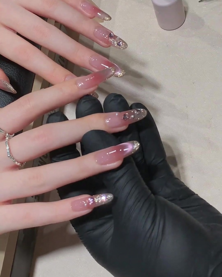 Pędzelek nakłada lśniący top coat na wykończony wzór z cyrkoniami.