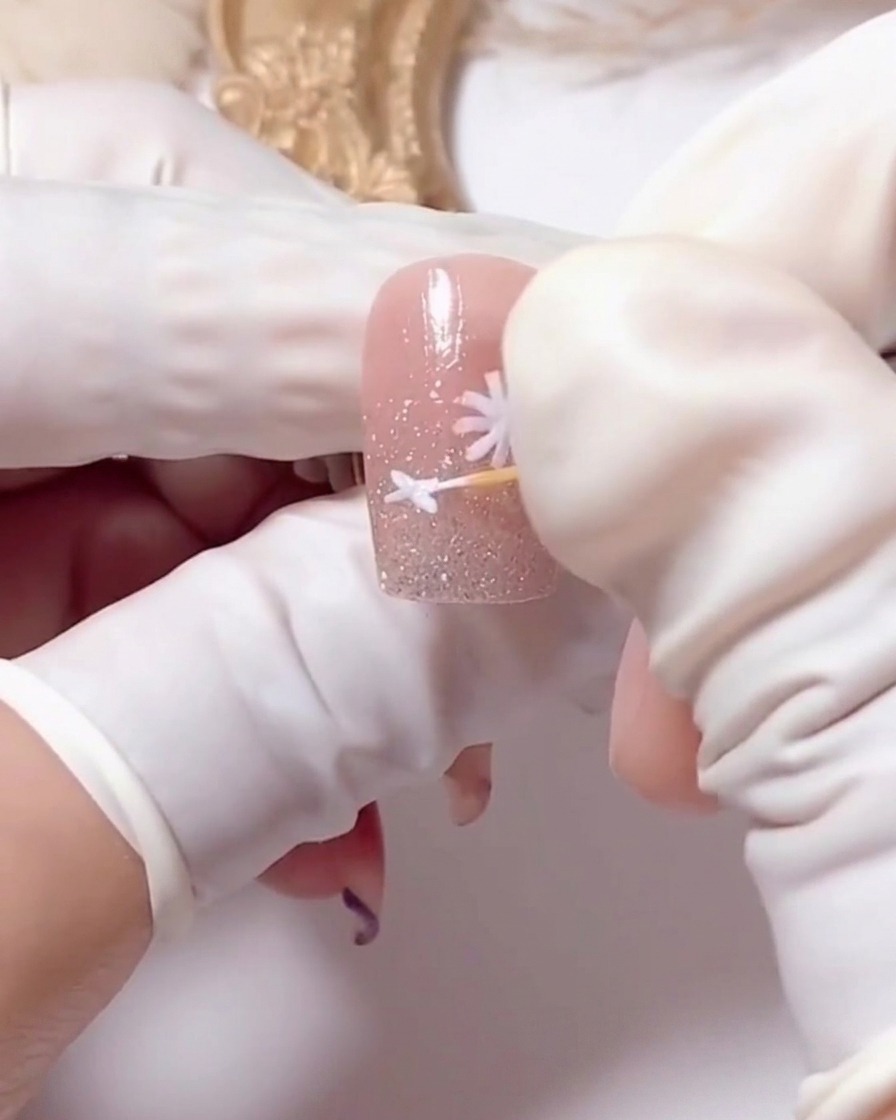 Wykałaczka używana do oddzielania białych płatków stokrotki.