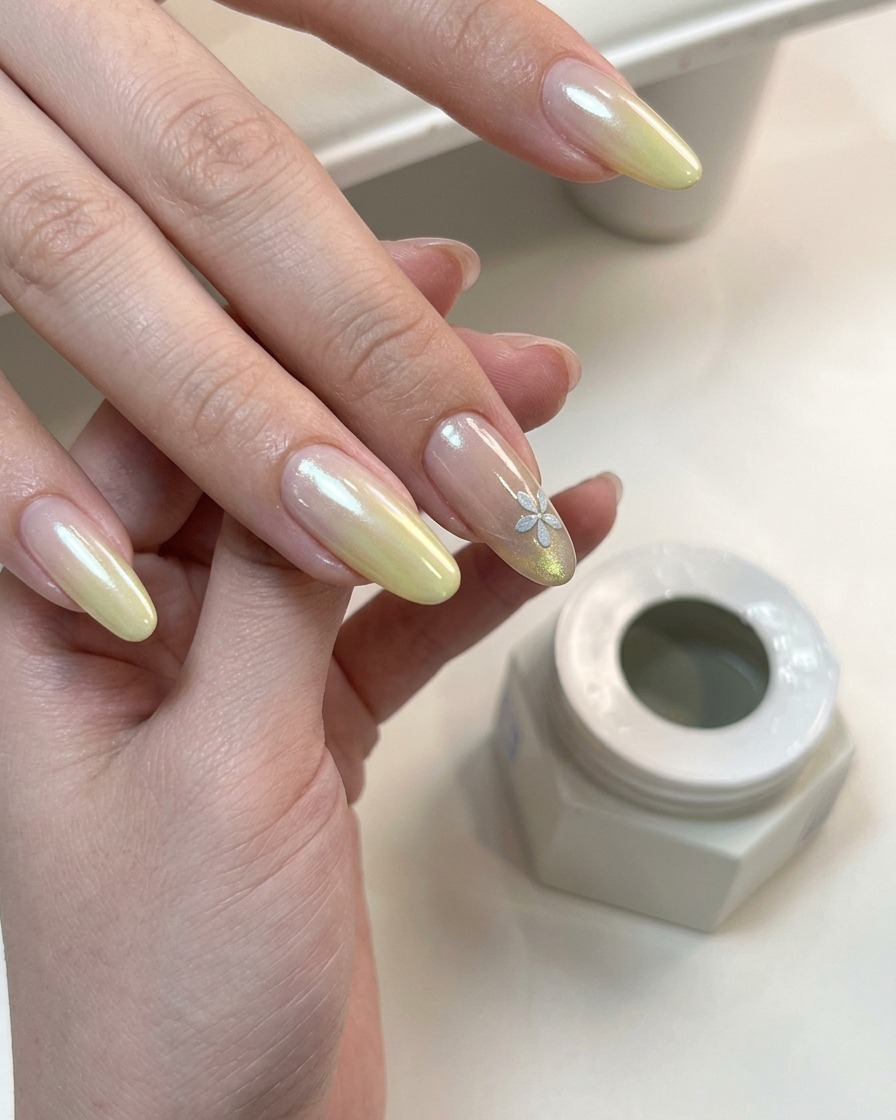 Dłoń z ukończonym gradientem i kwiatowym nail artem utwardzana pod lampą UV.