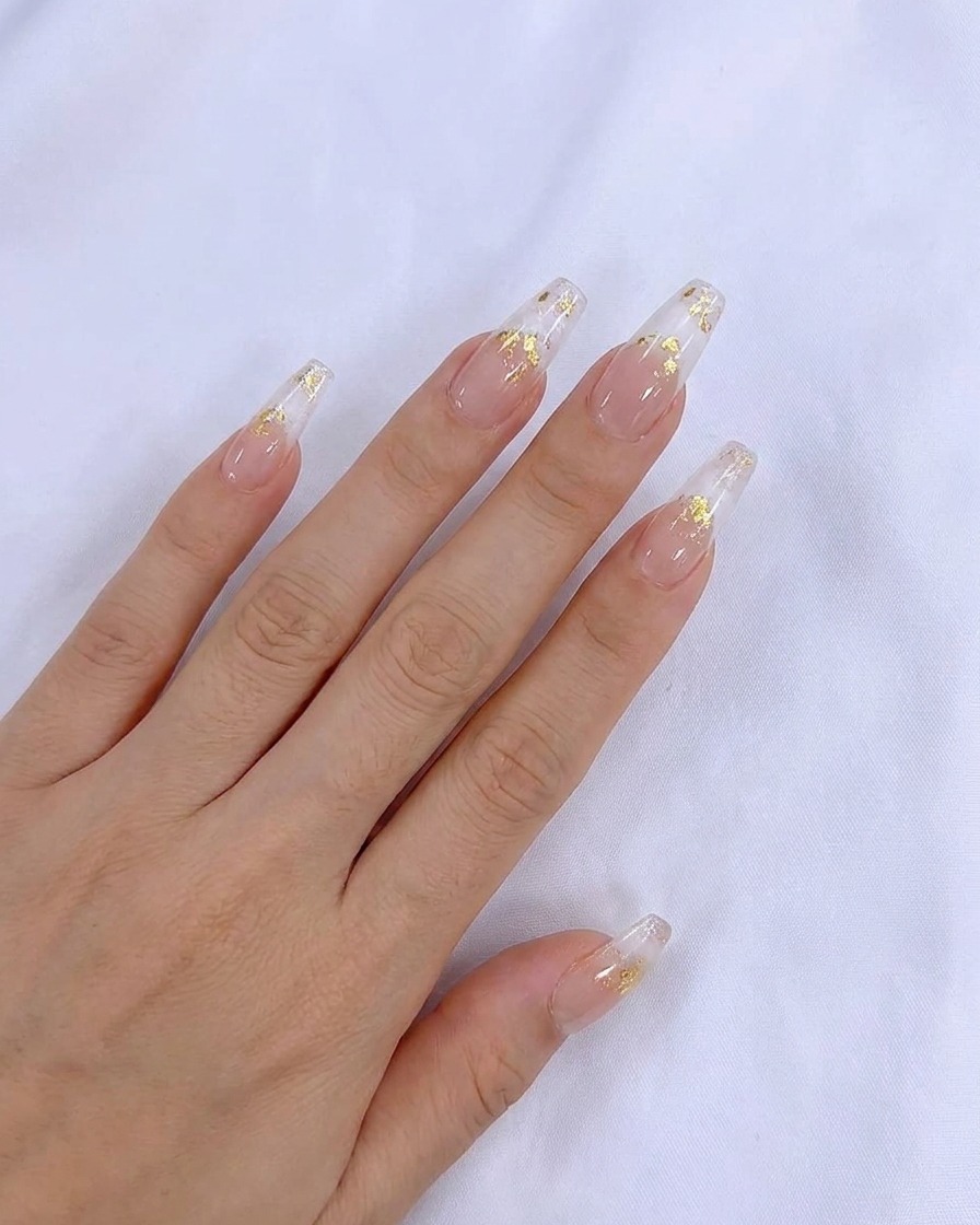 Ein Pinsel trägt eine glatte Schicht transparentes Nude-Gel auf den Naturnagel auf.