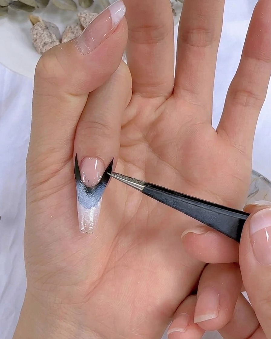 Nahaufnahme einer Hand mit Nail-Art unter einer UV-LED-Lampe.