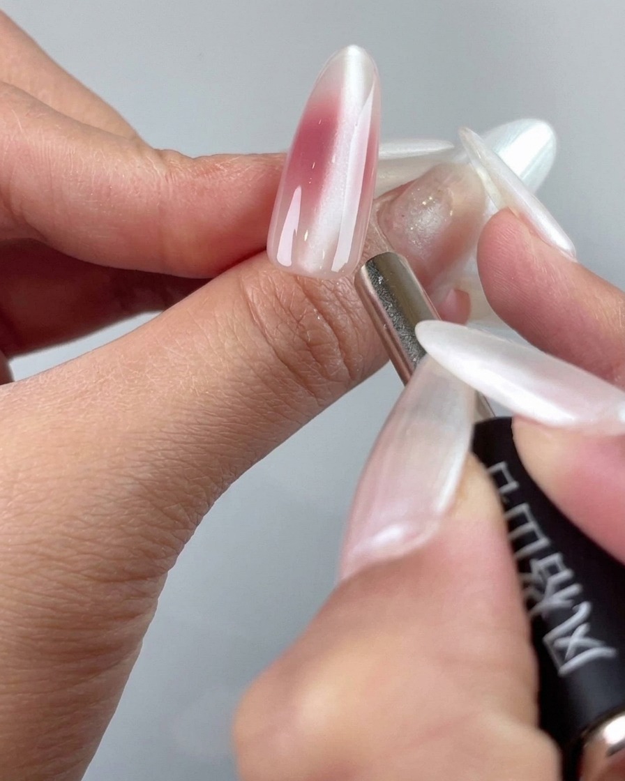 Cienka końcówka narzędzia magnetycznego układająca drobinki cat-eye w pobliżu skórek.