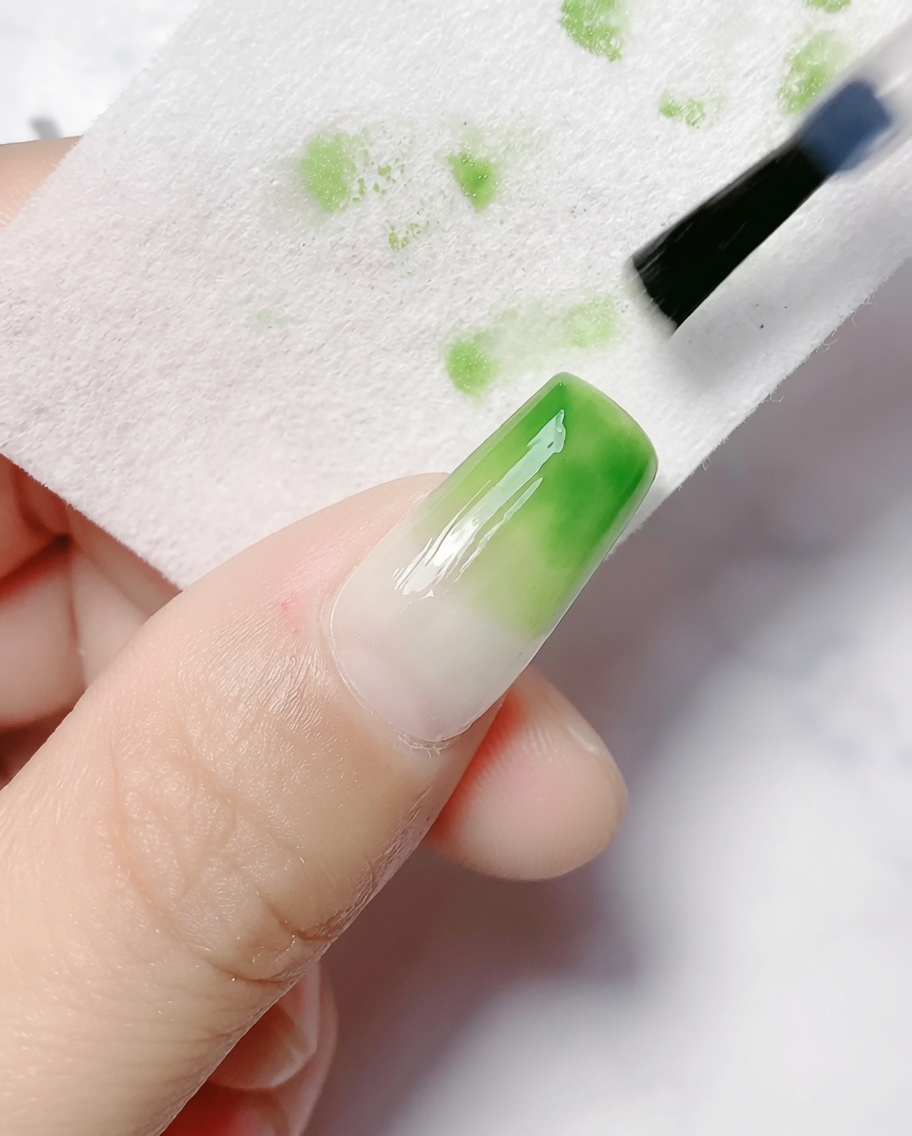 Wacik nasączony cleanerem wycierający lepką warstwę dyspersyjną z utwardzonego paznokcia z gradientem.