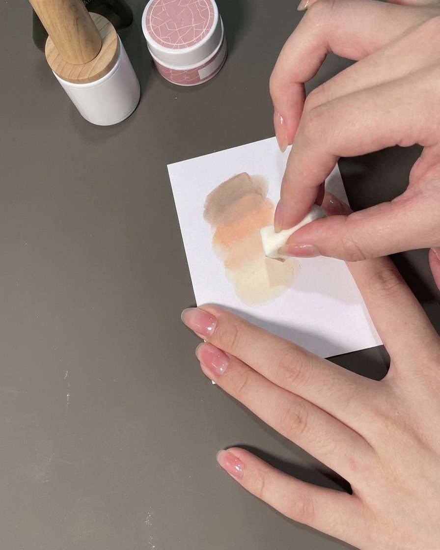 Ein Schwamm tupft Gel auf einen Nagel, um einen Ombré-Farbverlauf zu bilden.