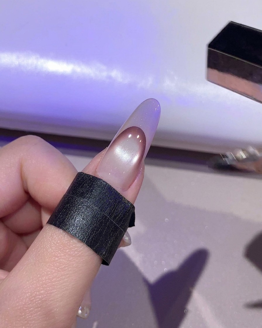 Paznokieć utwardzający się pod fioletowym światłem wewnątrz lampy UV/LED.