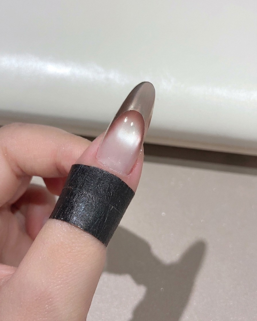 Pędzelek do paznokci nakładający czysty, błyszczący top coat na ukończony różowo-złoty french.