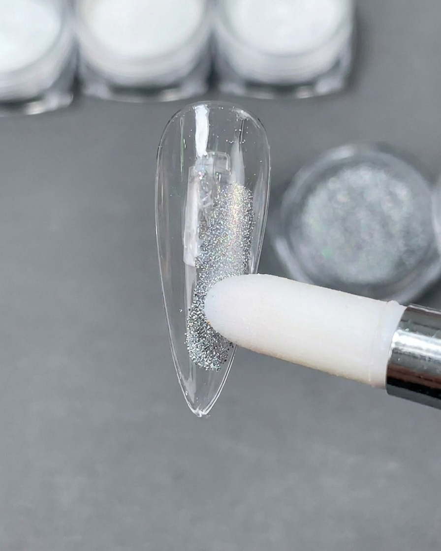 Aplikator gąbkowy umieszczający srebrny pyłek holograficzny laser na jasnym paznokciu stiletto.