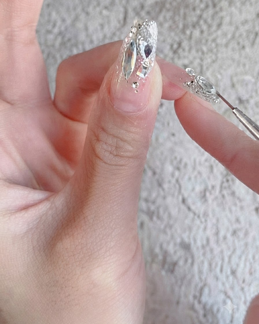Pędzelek do paznokci nakładający błyszczący top coat wzmacniający na w pełni ukończony wzór paznokci z cyrkoniami.