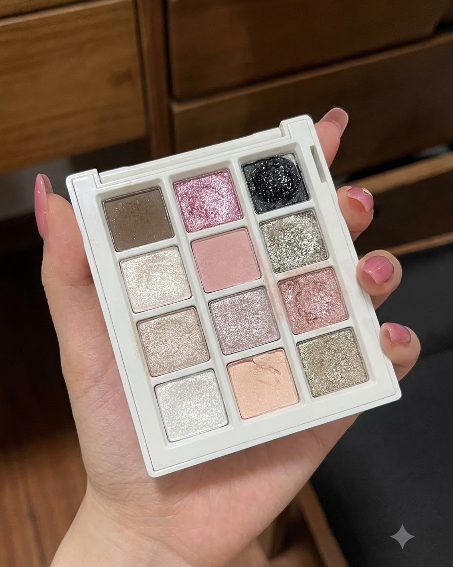 Nahaufnahme einer Hand, die eine Gel-Palette mit Pastell- und Glitzerfarben hält.
