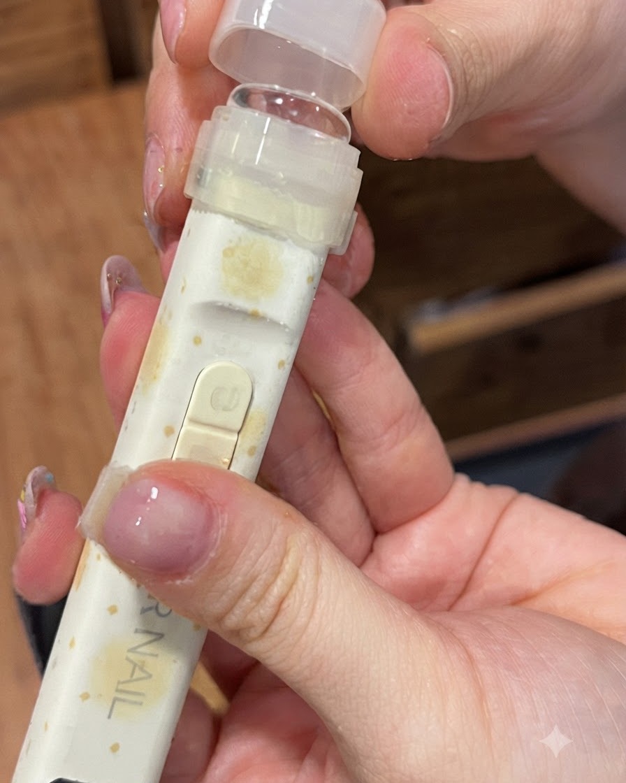 Eine UV-Lampe mit klarem Silikonaufsatz wird über einen Finger gehalten.