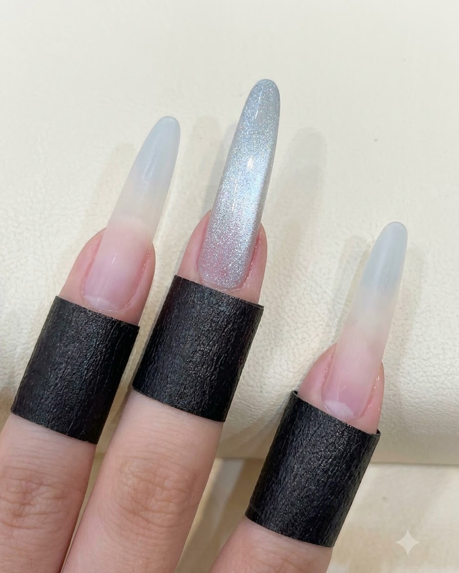Dłoń pokazująca długie paznokcie migdałki z ukończonym odbiciem cat eye w stylu kuli świetlnej.