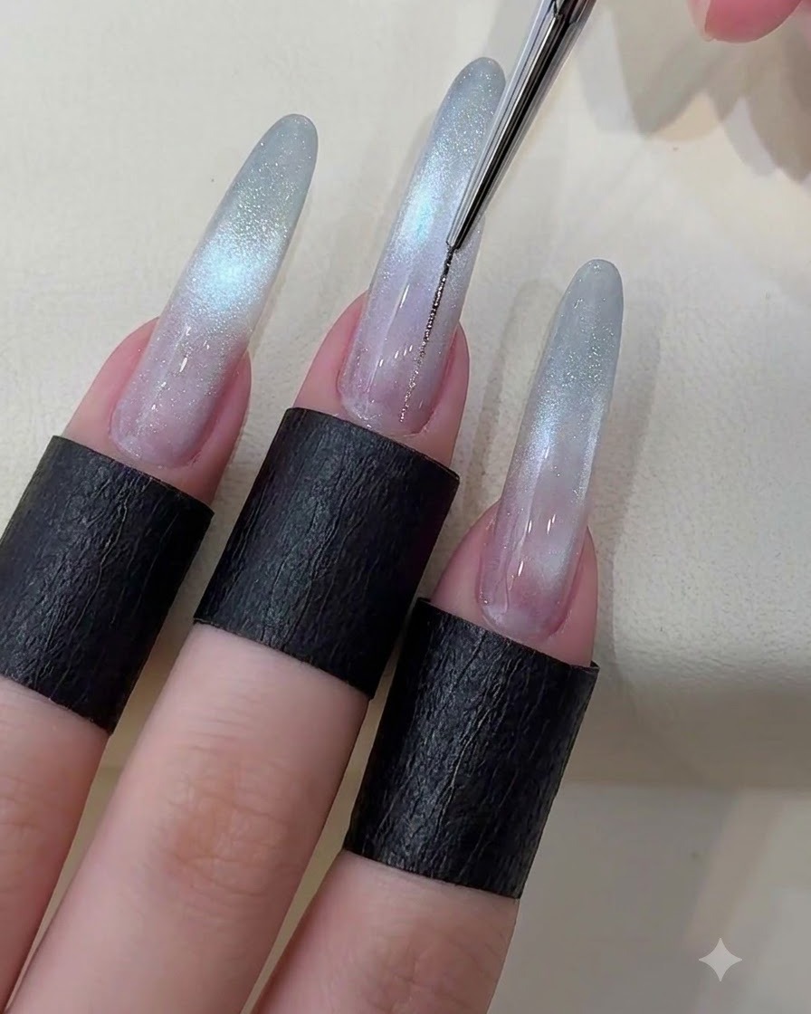 Cienki pędzelek liniowy rysujący cienką, metaliczną srebrną linię wzdłuż środka paznokcia starry cat eye.