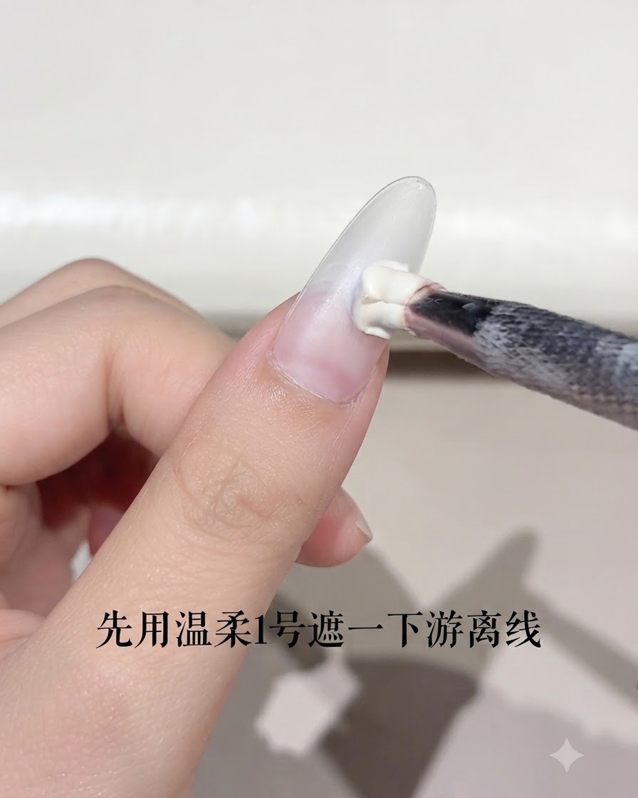 Ein Nagelpinsel trägt eine kleine Menge weißes Gel auf die Nagelspitze eines mandelförmigen Nagels auf.