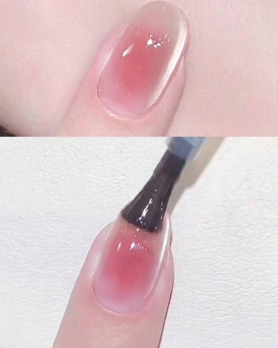 Ein schwarzer Nagelpinsel trägt einen klaren, glänzenden Top Coat über ein fertiges rosa Blush Cat Eye Nageldesign auf.