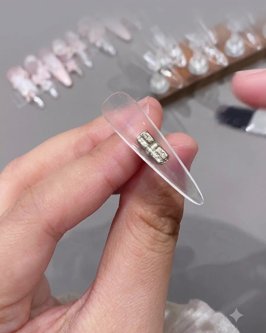 Mały pędzelek nakładający bezbarwny top coat na wewnętrzną, pustą sekcję przezroczystego sztucznego tipsa.