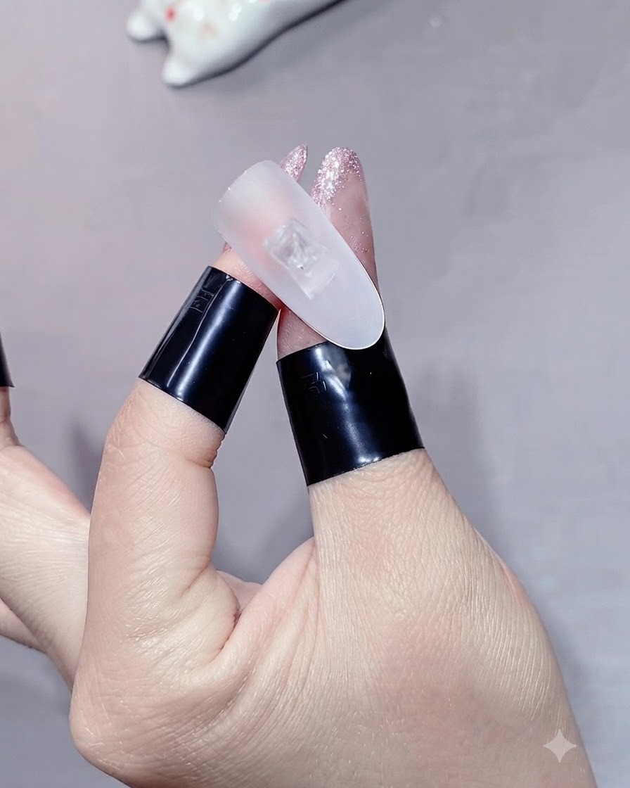 Ein Finger unter einer Mini-UV- und LED-Lampe zum Aushärten.