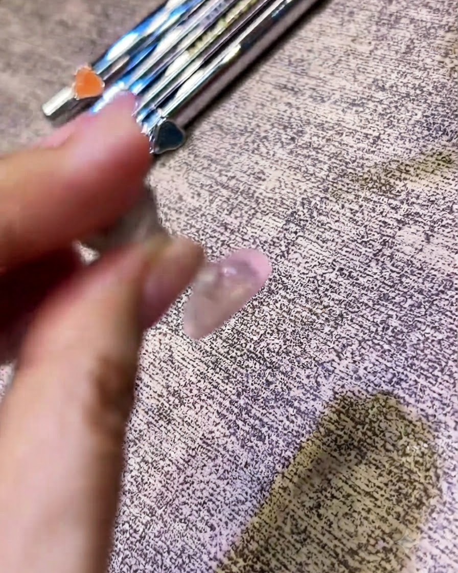 Pędzelek aplikujący bezbarwny top coat na paznokieć z efektem chromu.