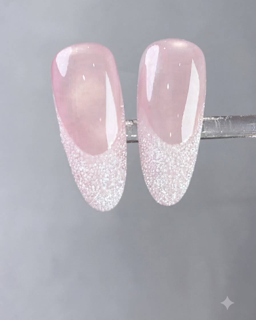 Ein Pinsel trägt eine Schicht fließenden milchig-weißen Gels auf einen Naturnagel auf.