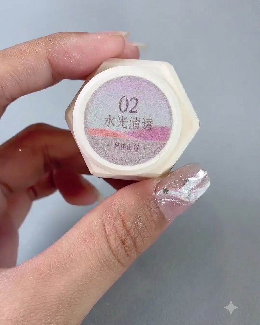 Ein Paar Hände hält ein Glas mit der Nummer 2 Wasserglanz transluzenten Cat-Eye-Gel-Politur hoch.