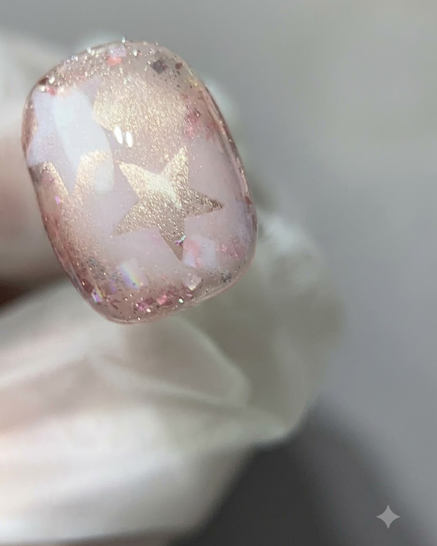 Zbliżenie utwardzonego paznokcia z różowym żelem cat-eye pod lampą utwardzającą.