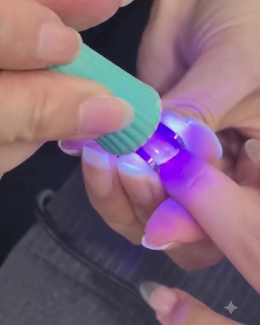 Mini lampa UV lub LED utwardzająca strukturalną warstwę żelu na palcu.