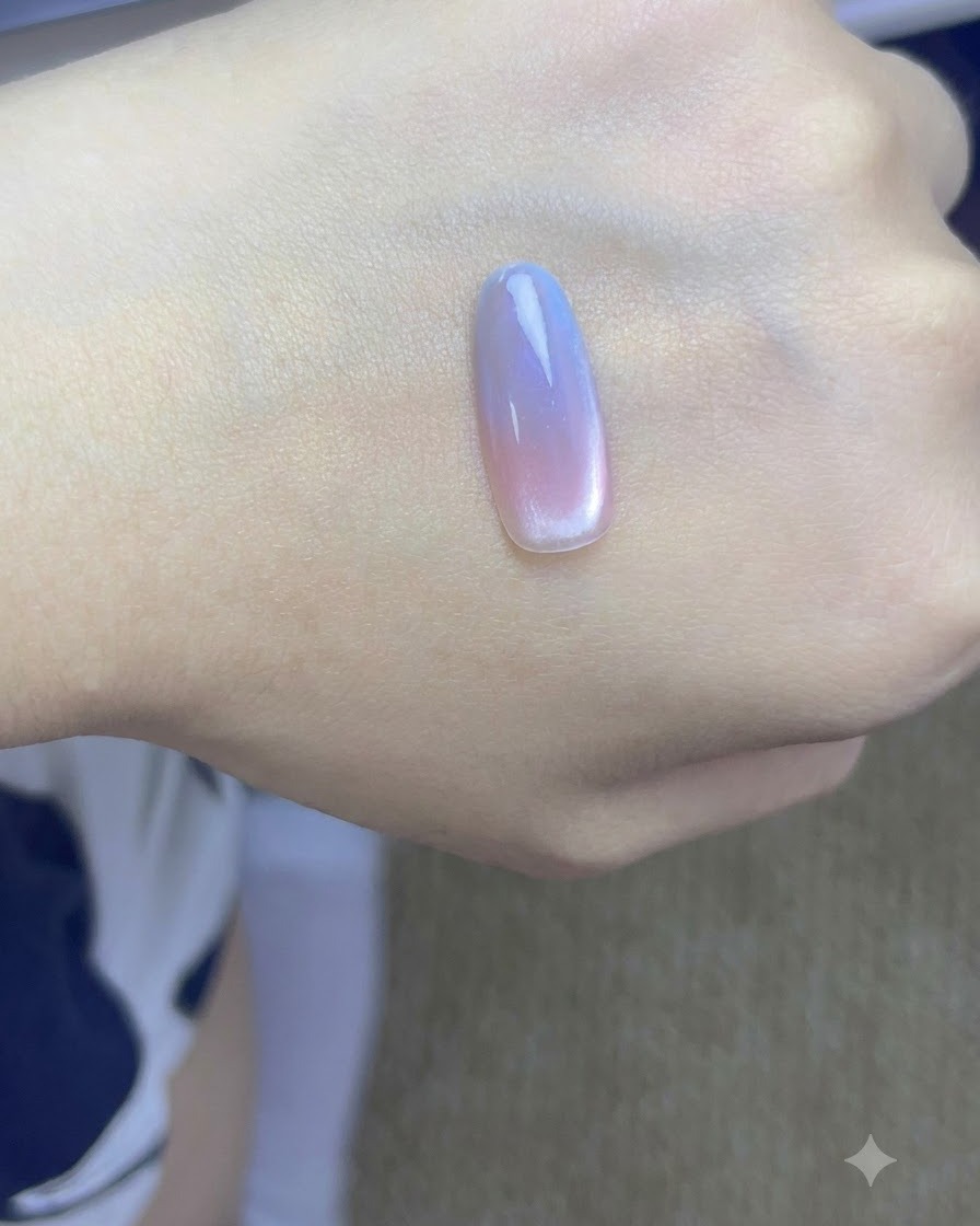 Dłoń z ukończonymi paznokciami gradient cat eye utwardzająca się pod profesjonalną lampą UV do paznokci.