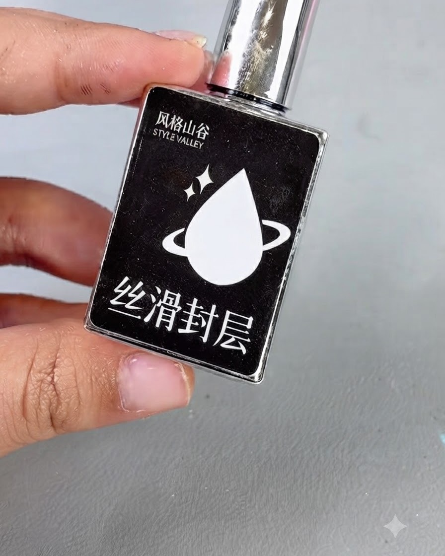 Czarna buteleczka ze srebrną nakrętką i białą ikoną kroplą z tekstem, reprezentująca gładki żel top coat.