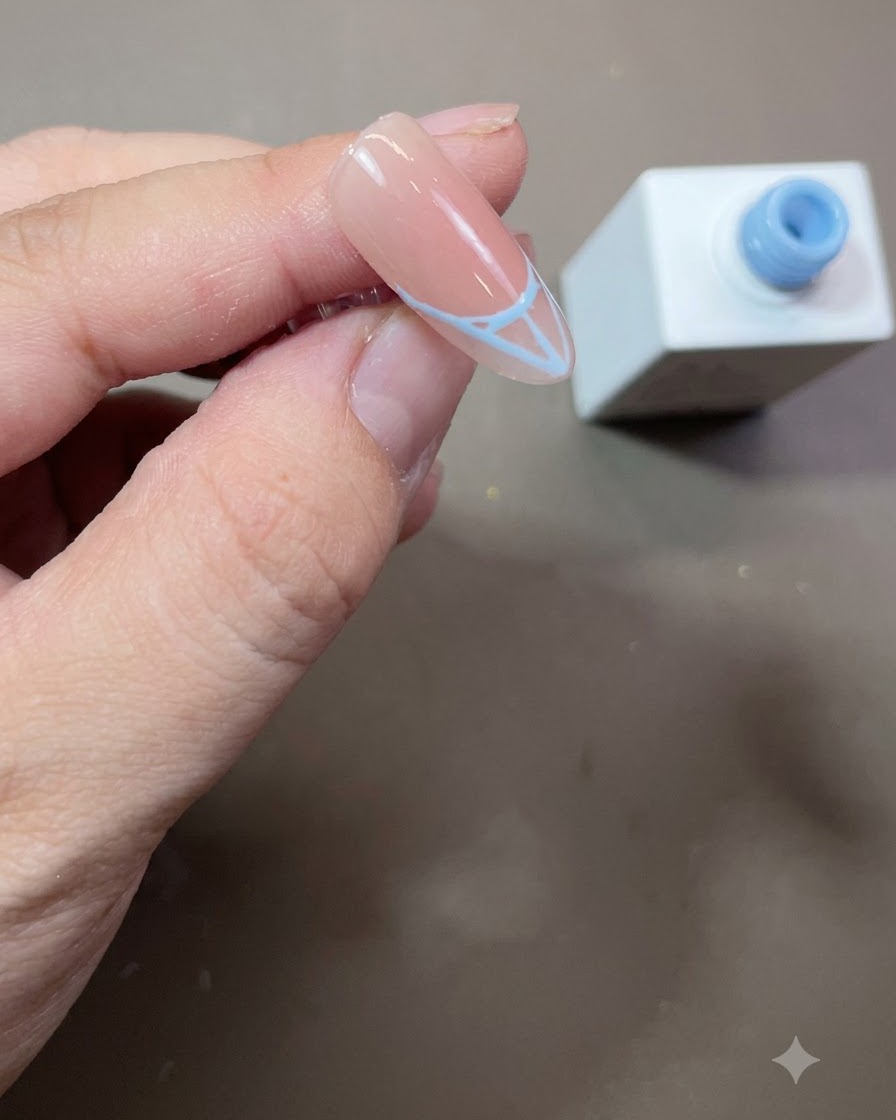 Eine fertiggestellte blaue French-Tip-Umrandung, solide ausgefüllt mit blauem Gel-Nagellack auf einem mandelförmigen Nagel.