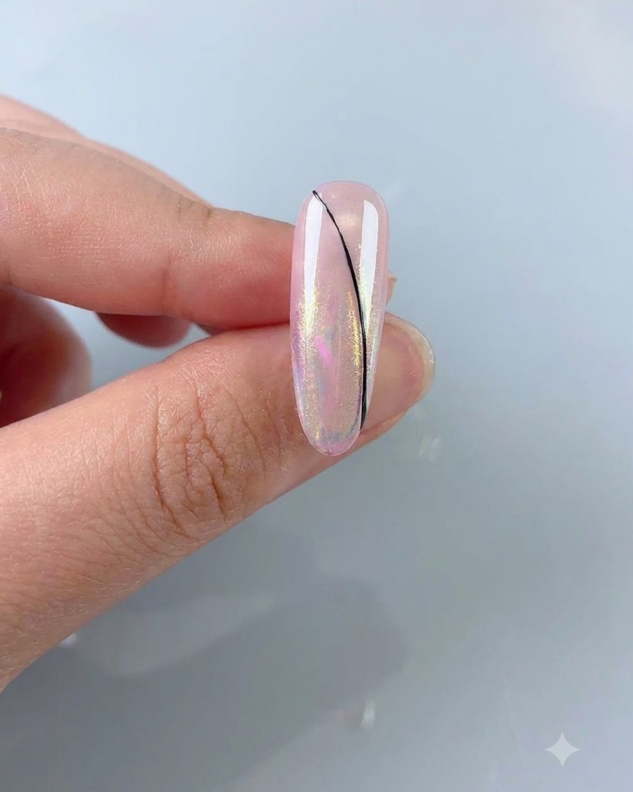 Ein feiner Linienpinsel zeichnet eine zarte, schwarze geschwungene Linie auf einen rosa Aurora-Nagel.